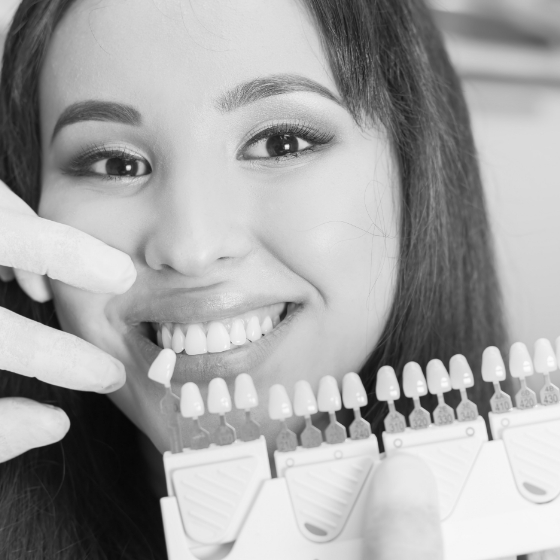 Young woman trying on veneers in dental chair