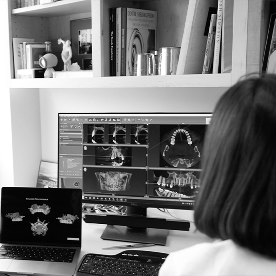 Dentist looking at computer screen showing digital models of teeth