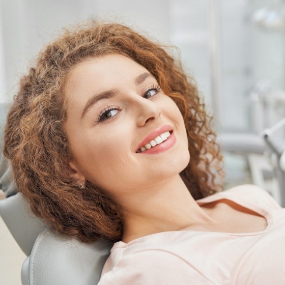 Woman leaning back and smiling in dental chair