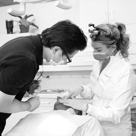 Dentist and assistant treating a dental patient