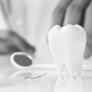 Model of tooth and dental mirror on desk