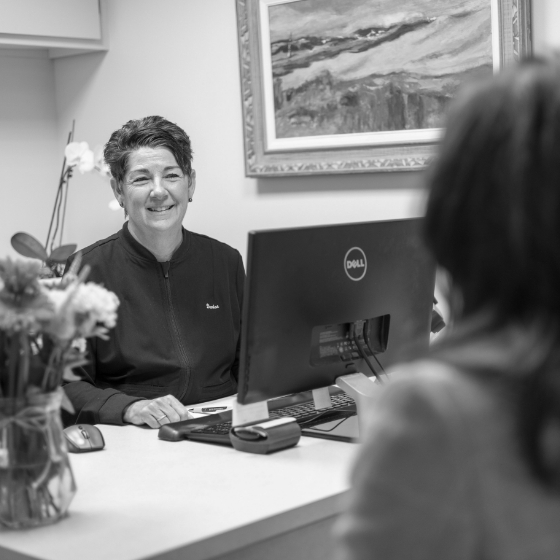 Dental team member sitting at desk with computer