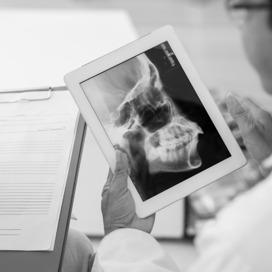 Dentist holding tablet with X ray of a skull
