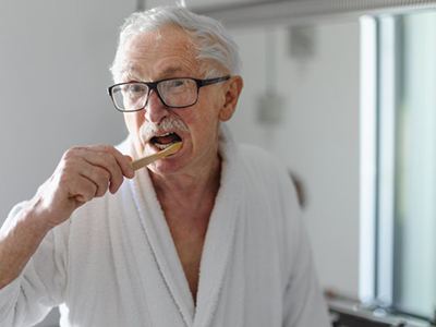 Patient in Boston brushing their dental implant dentures