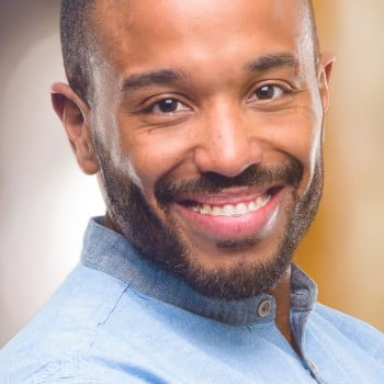 Man in denim shirt grinning