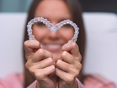 Man making heart shape with Invisalign trays