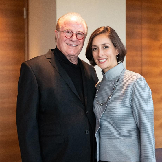 Doctor Mariam smiling with her husband at a speaking event