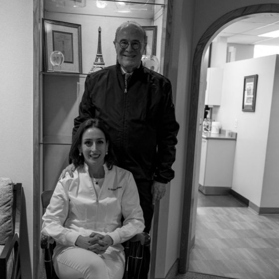 Doctor Kenneth Malament standing behind his wife sitting in chair