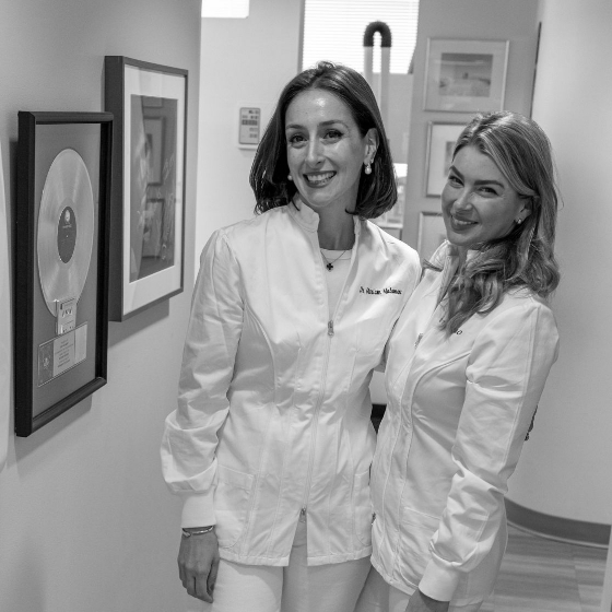 Two smiling dentists in hallway