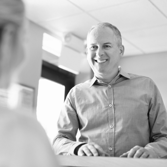 Man smiling at dental office receptionist