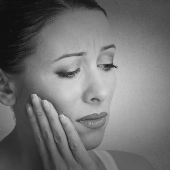 Woman holding her cheek in pain