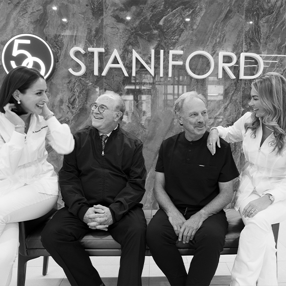 Four smiling dentist sitting on bench